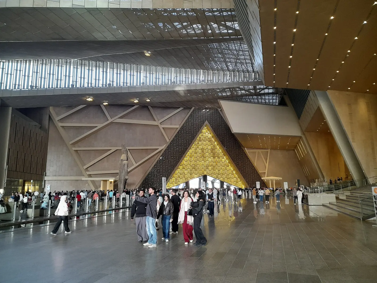 Visitors in the monumental entrance hall of the Grand Egyptian Museum